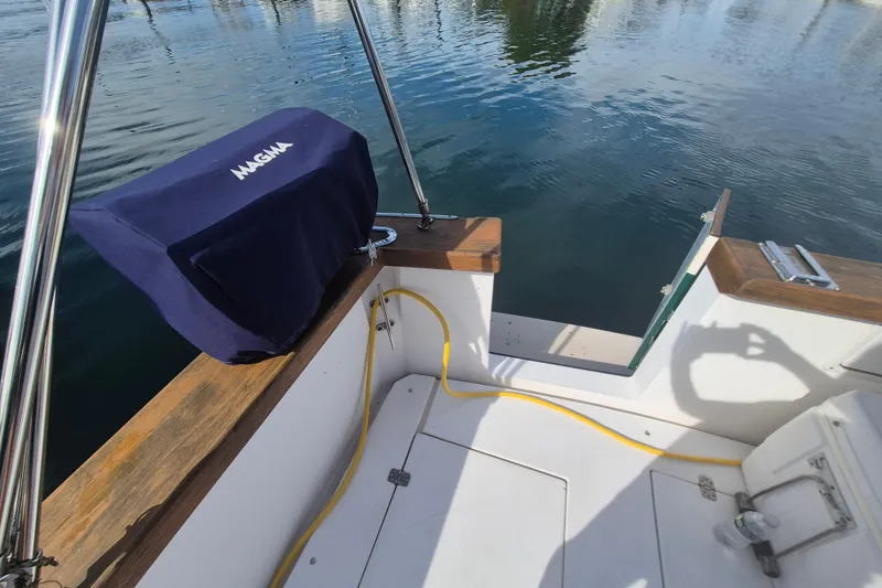 Slide: The Image of 1999 Nauset 33 Bridge Deck boat with covered grill and yellow hose on deck. - 42