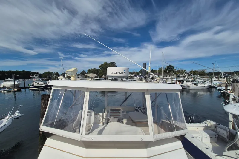 Slide: The Image of 1999 Nauset 33 Bridge Deck boat docked at a marina under a partly cloudy sky. - 47