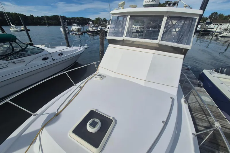 Slide: The Image of 1999 Nauset 33 Bridge Deck boat docked at marina, surrounded by other vessels. - 48