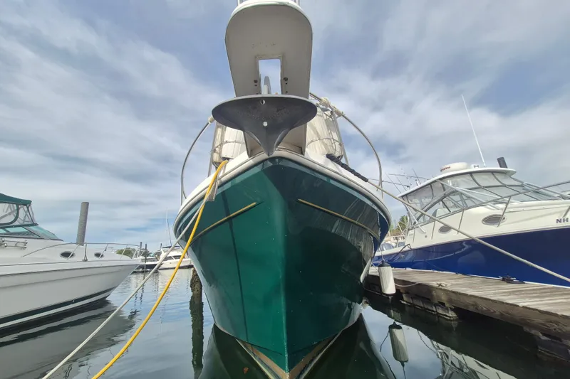 Slide: The Image of 1999 Nauset 33 Bridge Deck boat docked at marina, front view. - 51