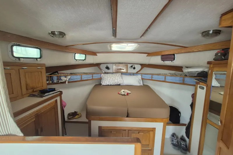 Slide: The Image of Cozy cabin interior of 1999 Nauset 33 Bridge Deck boat with bed and storage. - 6