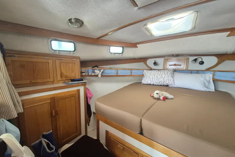 Slide: The Image of Cozy cabin interior of 1999 Nauset 33 Bridge Deck with bed and wooden storage. - 7