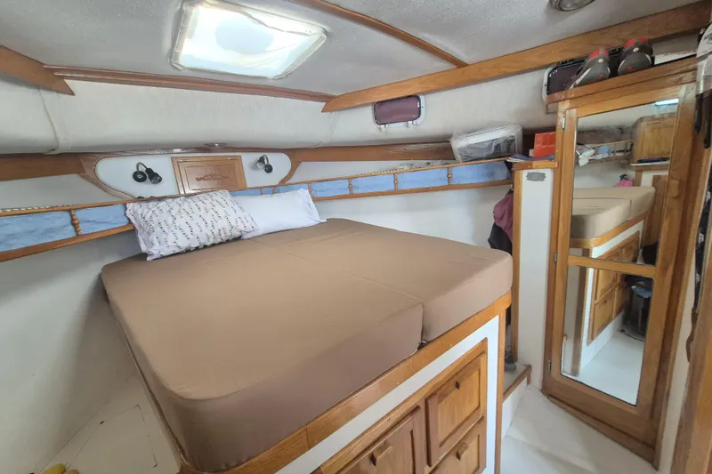 Slide: The Image of Cozy cabin interior of 1999 Nauset 33 Bridge Deck with bed and wooden storage. - 8