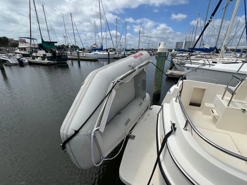 Slide: The Image of Camano 31 Troll boat with dinghy attached, docked in a marina, 2001 model. - 11