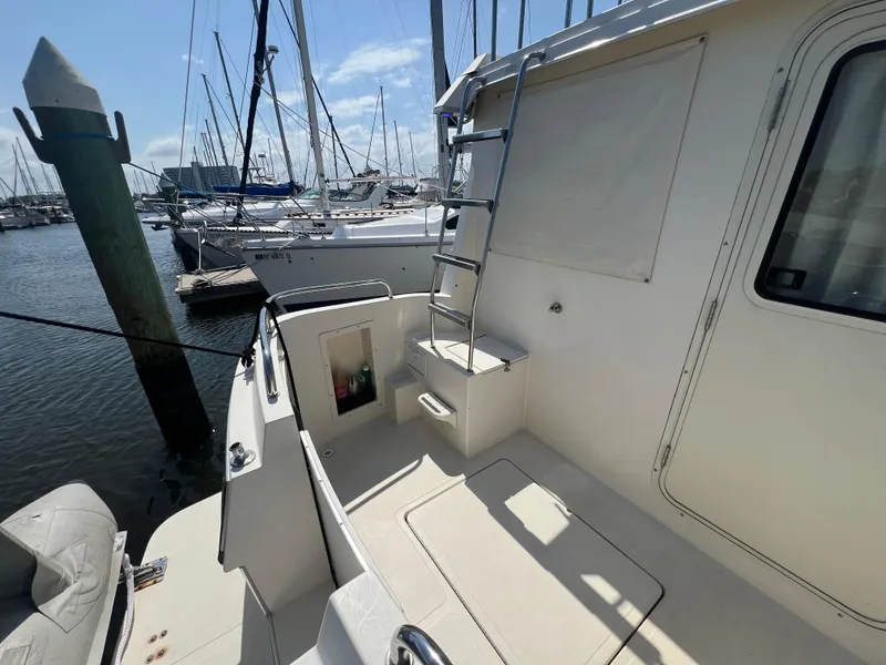 Slide: The Image of 2001 Camano 31 Troll boat deck with ladder, docked at marina under clear sky. - 17