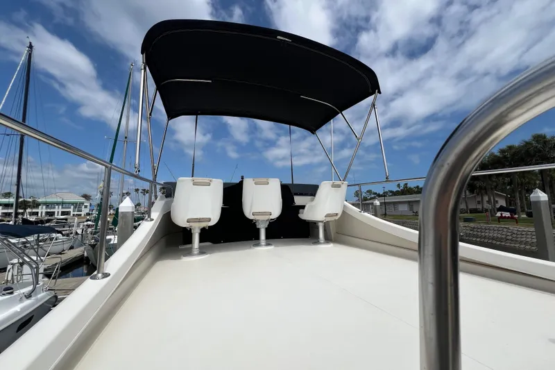 Slide: The Image of 2001 Camano 31 Troll boat deck with seating and canopy under a blue sky. - 30