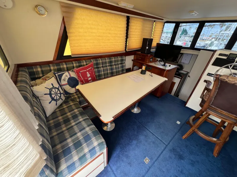 Slide: The Image of Interior of 2001 Camano 31 Troll boat with plaid seating, table, and nautical decor. - 32