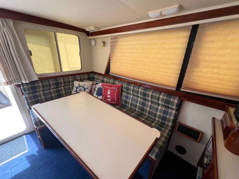 Slide: The Image of Interior of 2001 Camano 31 Troll boat with plaid seating and a white table. - 33