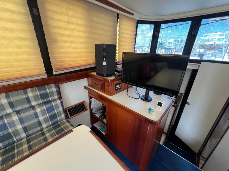 Slide: The Image of Interior of 2001 Camano 31 Troll boat with TV, plaid seating, and wooden cabinetry. - 34