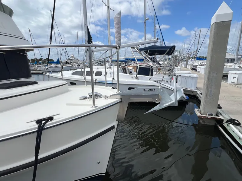 Slide: The Image of 2001 Camano 31 Troll docked at marina, surrounded by other boats under a partly cloudy sky. - 9