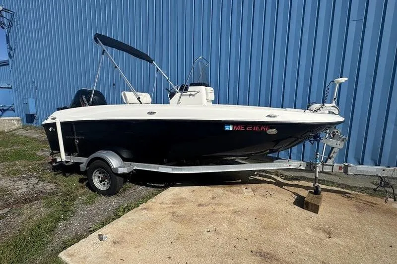 The Image of 2017 Bayliner Element F18 boat on trailer, parked beside blue building. - 2