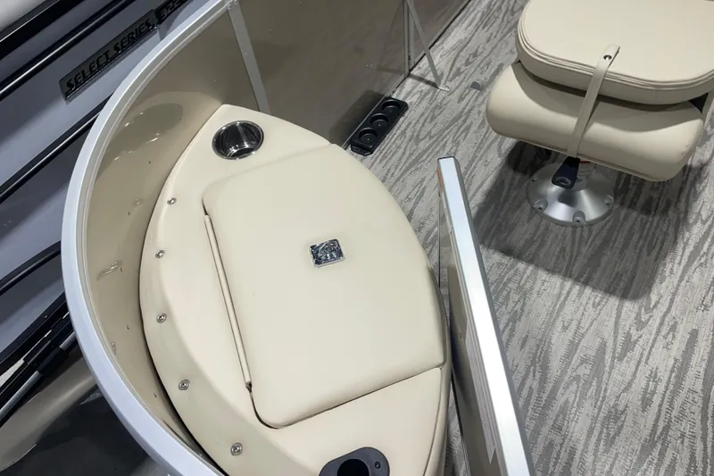 Slide: The Image of 2025 SunCatcher Select 320FC boat interior with beige seating and carpeted flooring. - 11