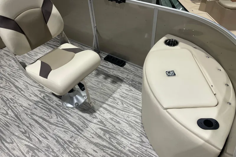 Slide: The Image of 2025 SunCatcher Select 320FC boat interior with beige seating and storage compartment. - 12