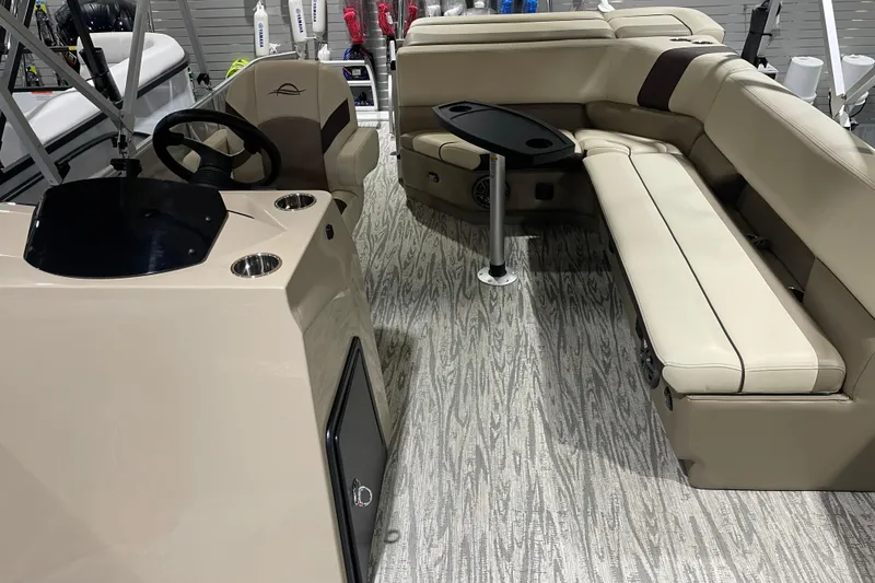 Slide: The Image of 2025 SunCatcher Select 320FC boat interior with beige seating and steering console. - 13