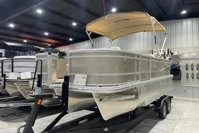 Slide: The Image of 2025 SunCatcher Select 320FC pontoon boat displayed indoors on a trailer. - 15