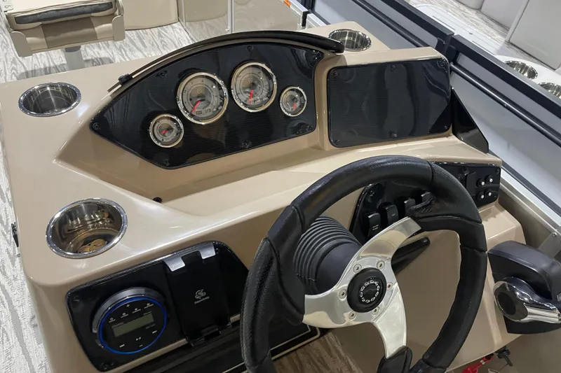 Slide: The Image of 2025 SunCatcher Select 320FC boat dashboard with steering wheel and gauges. - 16