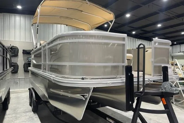Slide: The Image of 2025 SunCatcher Select 320FC pontoon boat in showroom, featuring sleek design and canopy. - 3