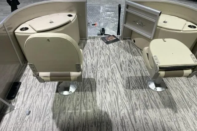 Slide: The Image of 2025 SunCatcher Select 320FC boat interior with beige seating and wood-patterned flooring. - 5
