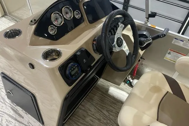 Slide: The Image of 2025 SunCatcher Select 320FC boat dashboard with steering wheel and gauges. - 6