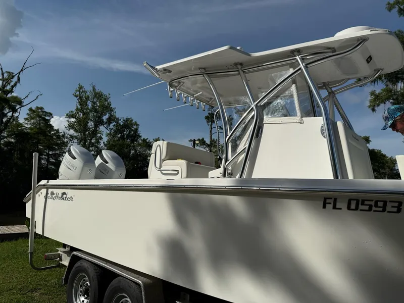 Slide: The Image of 2023 SeaHunter 28 Floridian boat on trailer, featuring dual engines and T-top, in a sunny outdoor setting. - 12