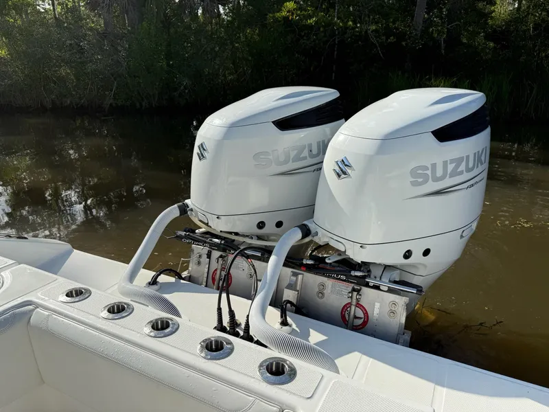 Slide: The Image of 2023 SeaHunter 28 Floridian with dual Suzuki outboard motors on a calm waterway. - 21