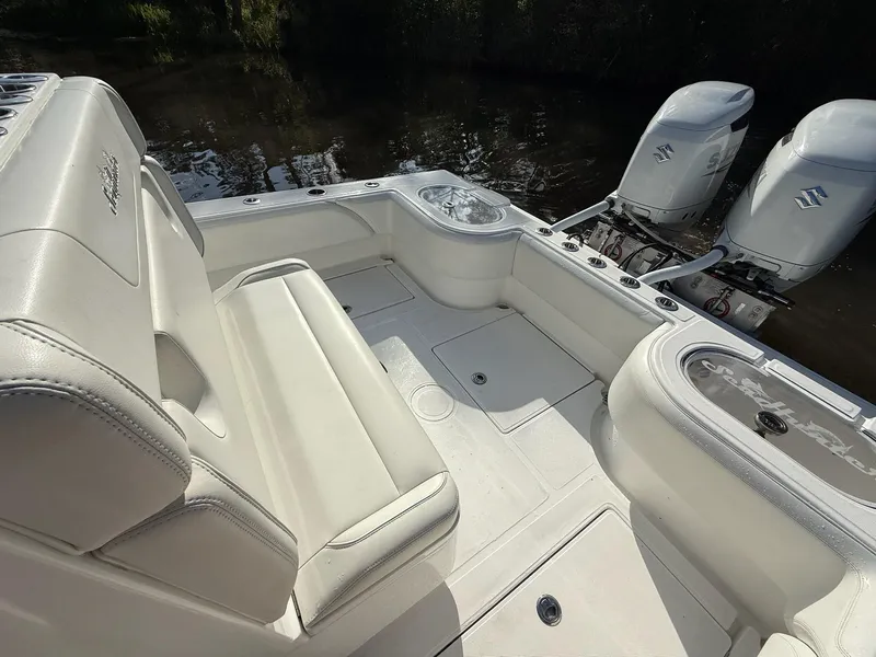Slide: The Image of 2023 SeaHunter 28 Floridian boat interior with dual outboard engines, featuring white seating and deck. - 25