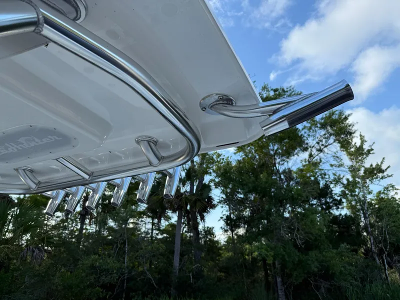 Slide: The Image of 2023 SeaHunter 28 Floridian boat detail with rod holders against a forested backdrop. - 40