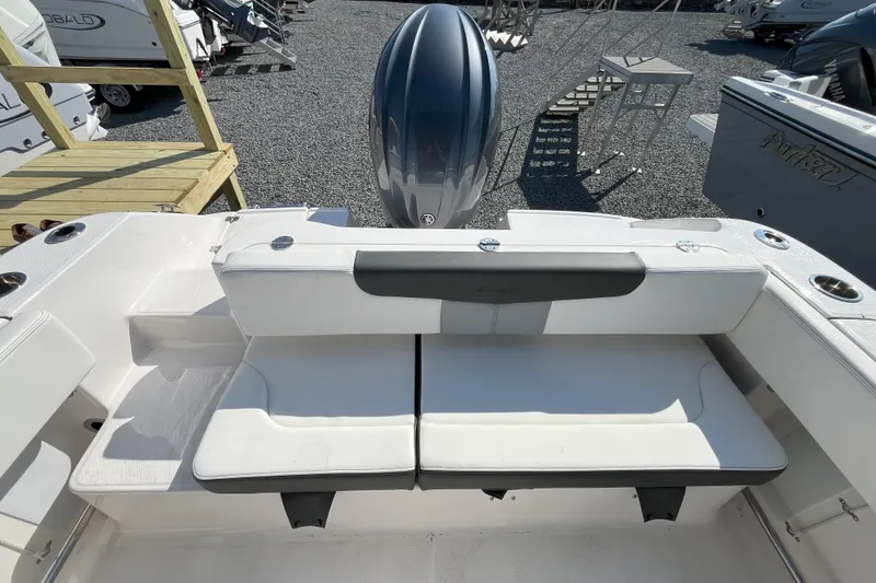 Slide: The Image of 2026 Robalo R202 Explorer boat seating area with outboard motor in a marina setting. - 3