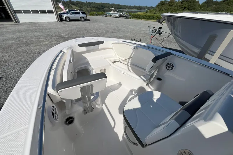 Slide: The Image of 2026 Robalo R202 Explorer boat interior with seating and storage, parked outdoors. - 7