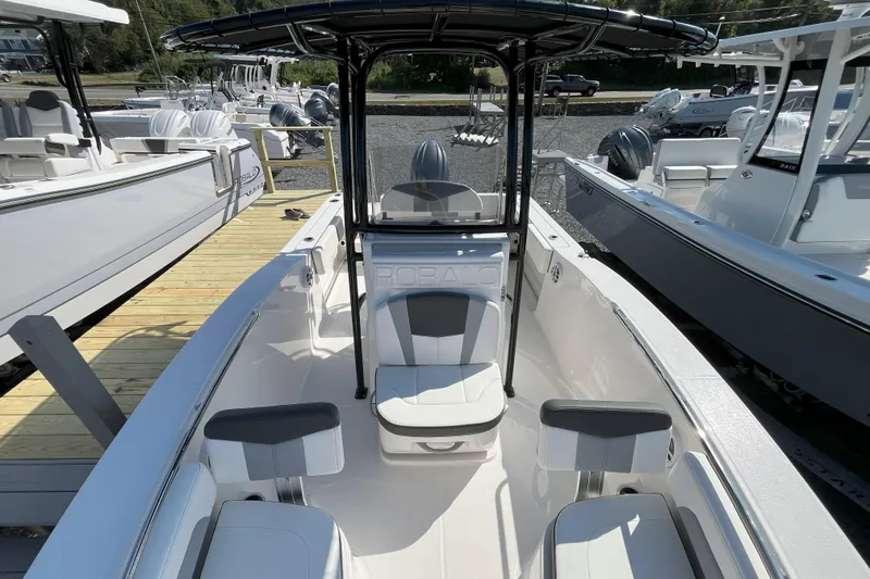 Slide: The Image of 2026 Robalo R202 Explorer boat interior with seating and console, docked outdoors. - 9