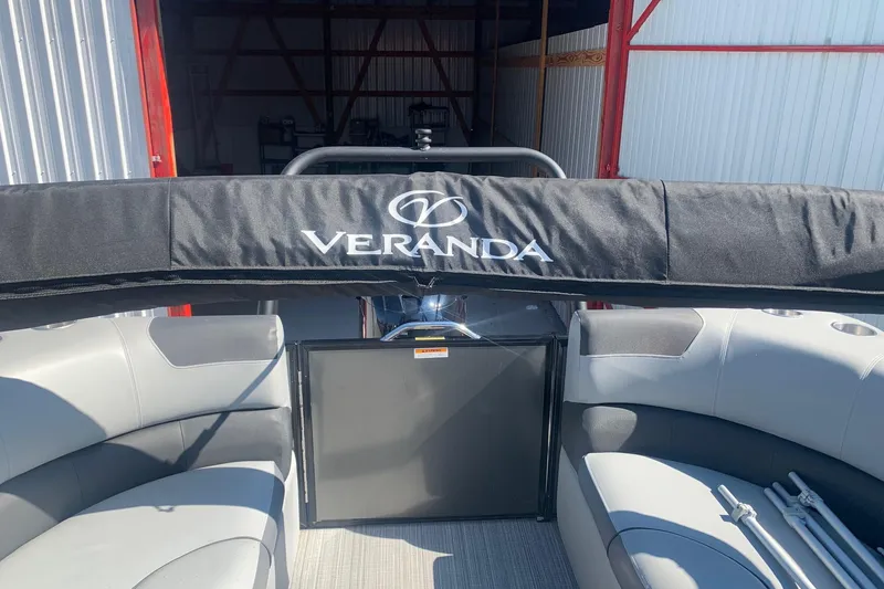 Slide: The Image of 2020 Veranda Relax VR22RC pontoon boat interior with seating and cover in storage. - 13