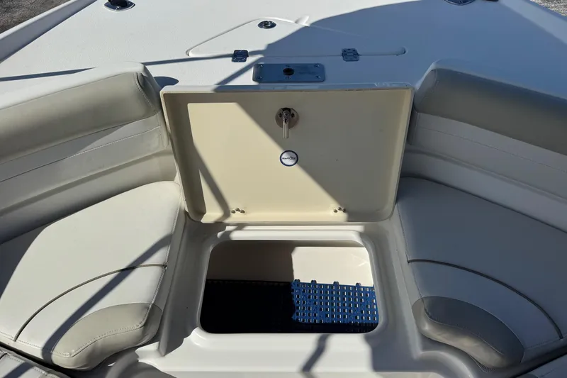 Slide: The Image of 2015 NauticStar 231 Angler boat storage compartment with cushioned seating. - 23