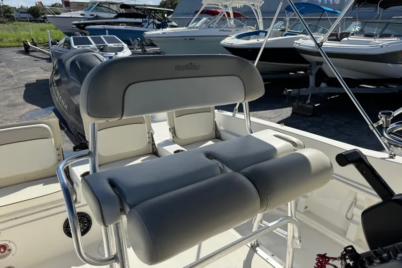 Slide: The Image of 2015 NauticStar 231 Angler boat interior with cushioned seating and steering console. - 25