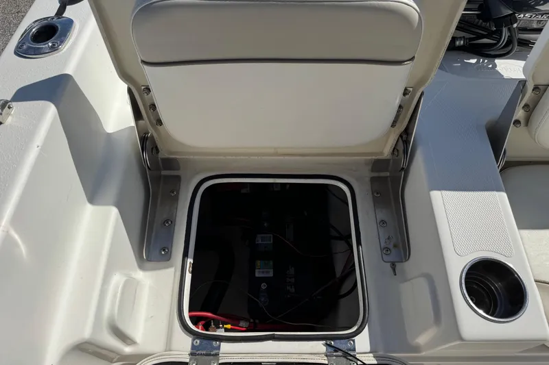 Slide: The Image of 2015 NauticStar 231 Angler boat battery compartment with open hatch and seating. - 28