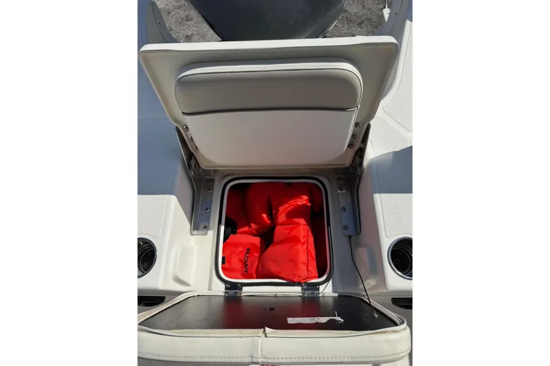Slide: The Image of 2015 NauticStar 231 Angler boat seat storage with red life jackets. - 29