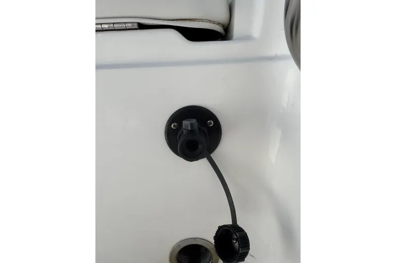 Slide: The Image of 2015 NauticStar 231 Angler boat detail showing a black plug on white surface. - 34