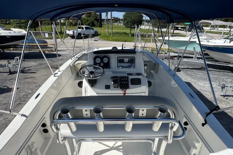 Slide: The Image of 2015 NauticStar 231 Angler boat interior with steering console and rod holders. - 5
