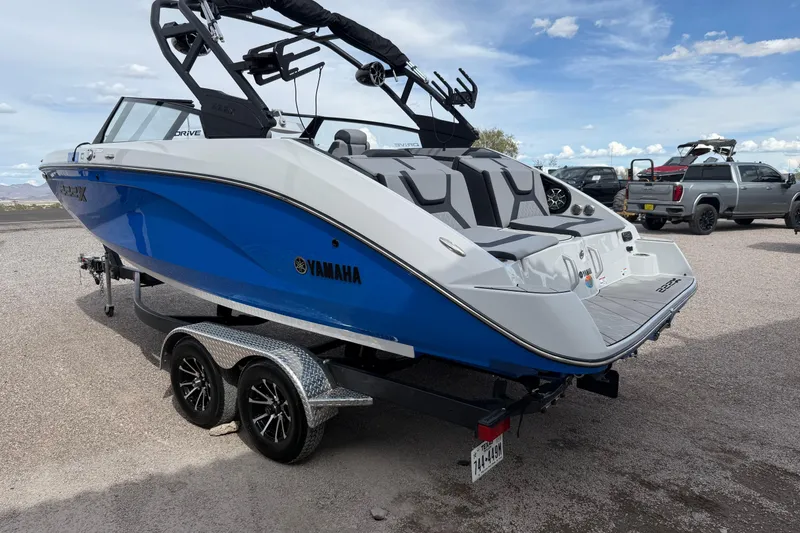 Slide: The Image of 2024 Yamaha Boats 222XD in blue, parked on a trailer under a clear sky. - 5