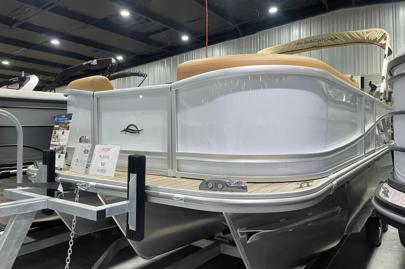 Slide: The Image of 2025 SunCatcher Fusion 322RC pontoon boat displayed indoors, featuring sleek design and modern amenities. - 0
