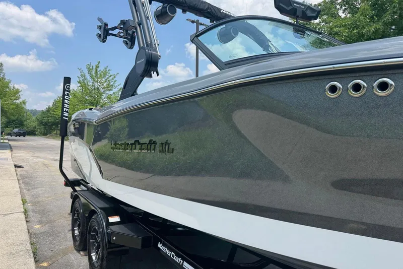 Slide: The Image of 2025 MasterCraft NXT24 boat on trailer, sleek design, parked outdoors. - 4