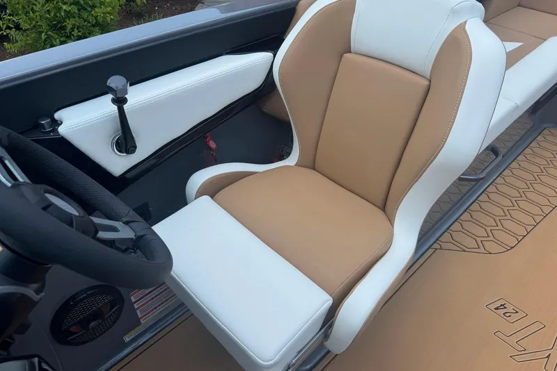 Slide: The Image of 2025 MasterCraft NXT24 boat interior with tan and white seating, steering wheel, and control panel. - 9