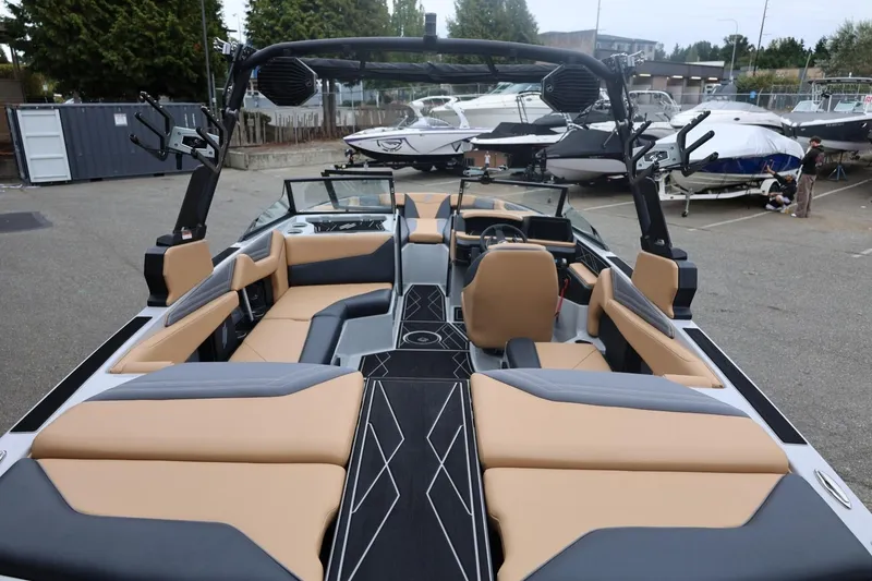 Slide: The Image of 2026 ATX Surf Boats 22 Type-S interior with tan and gray seating, docked among other boats. - 24