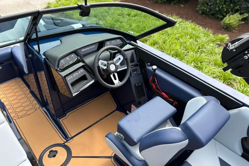 Slide: The Image of 2025 MasterCraft NXT20 boat interior with modern dashboard and sleek seating design. - 10