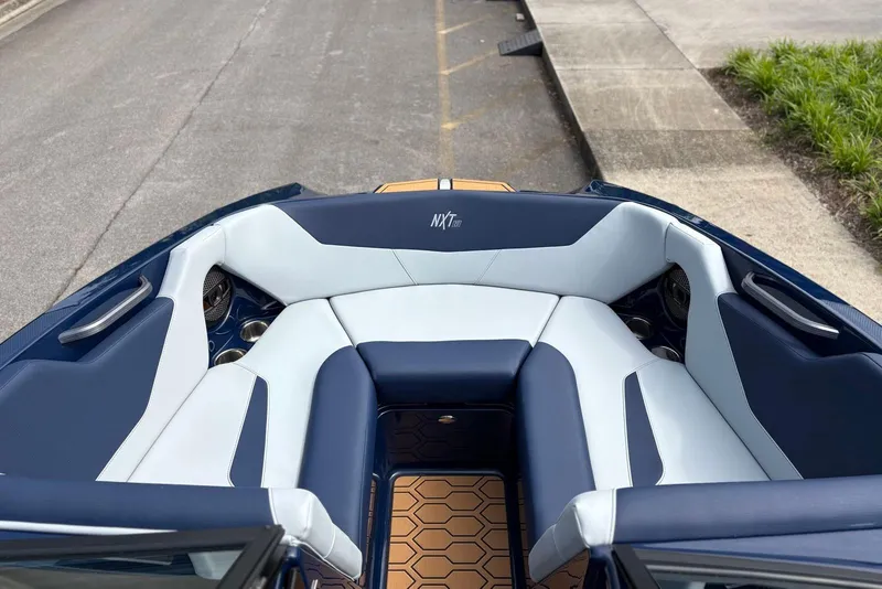 Slide: The Image of 2025 MasterCraft NXT20 boat interior with blue and white seating, hexagonal flooring. - 11