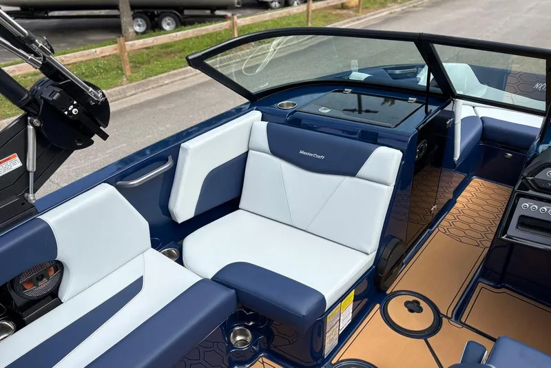 Slide: The Image of 2025 MasterCraft NXT20 boat interior with blue and white seating, modern design, and sleek dashboard. - 9
