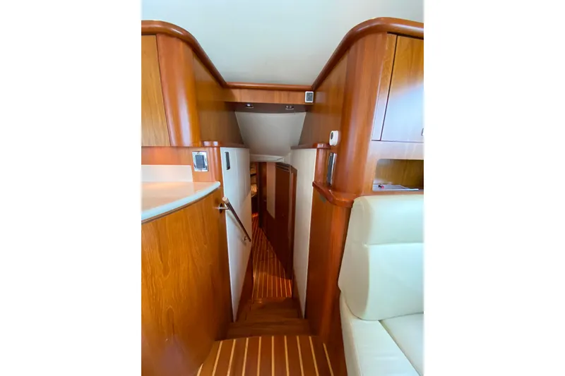 Slide: The Image of Interior of 2012 Tiara Yachts 4800 Convertible, featuring wooden cabinetry and stairs. - 12