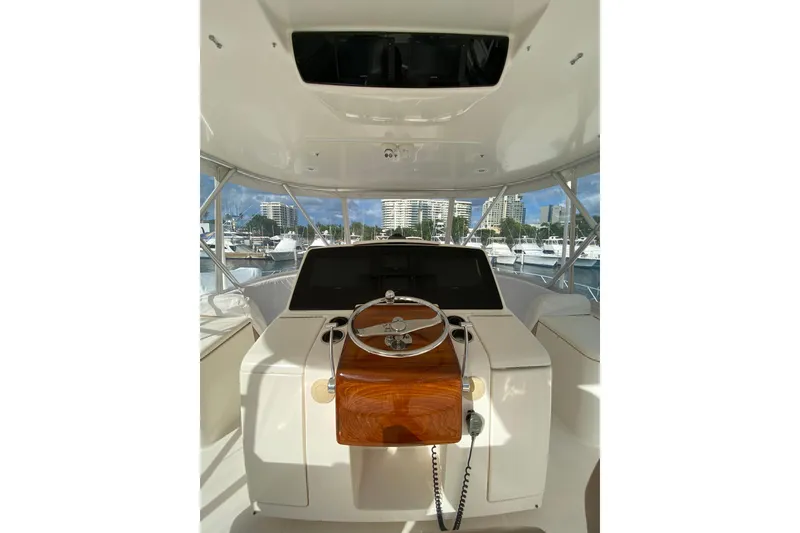 Slide: The Image of Interior view of 2012 Tiara Yachts 4800 Convertible helm with marina backdrop. - 3