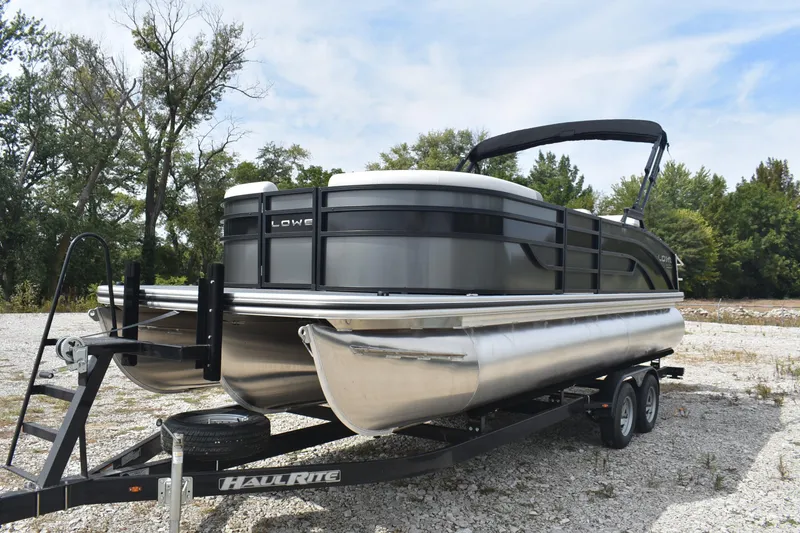 Slide: The Image of 2026 Lowe SS 230 DV pontoon boat on a trailer, parked outdoors. - 12