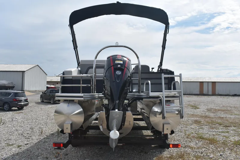 Slide: The Image of 2026 Lowe SS 230 DV pontoon boat with outboard motor, parked on gravel lot. - 8