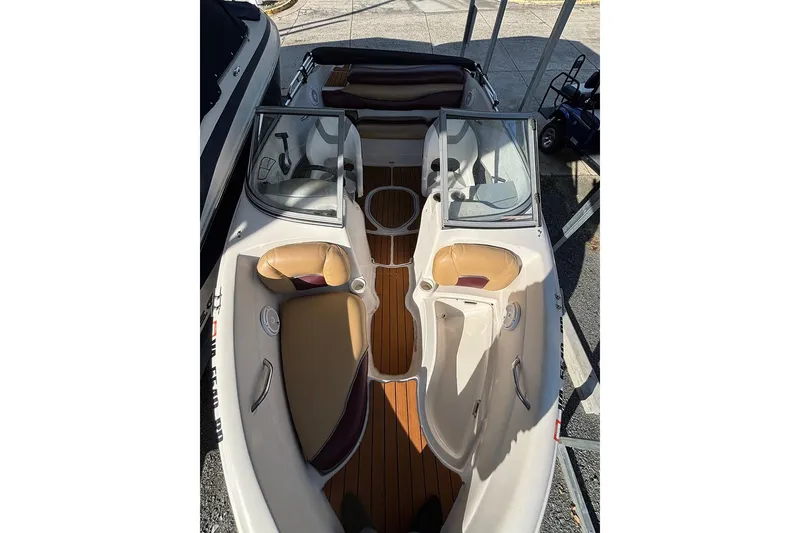 Slide: The Image of 2009 Tahoe Q5i Sport boat interior with tan seats and wood flooring. - 10